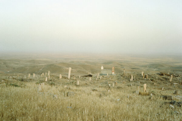 Grave stones of a graveyard are overlooking Sinjar mountain. Graveyards are often placed near to holy places and shrines of the Yezidi people. Many villages in the mountains existed till the 70's when the Saddam regime destroyed them due to a lack of control and moved people to mixed neighborhoods and planned cities.